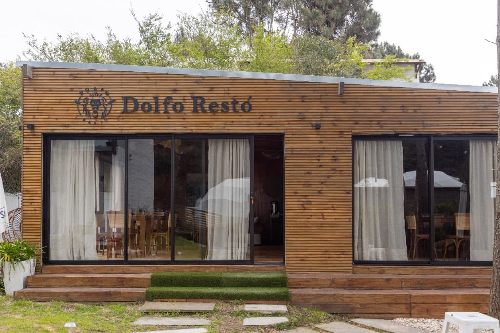 Fachada de madera de Dolfofo Restó, entre el jardín